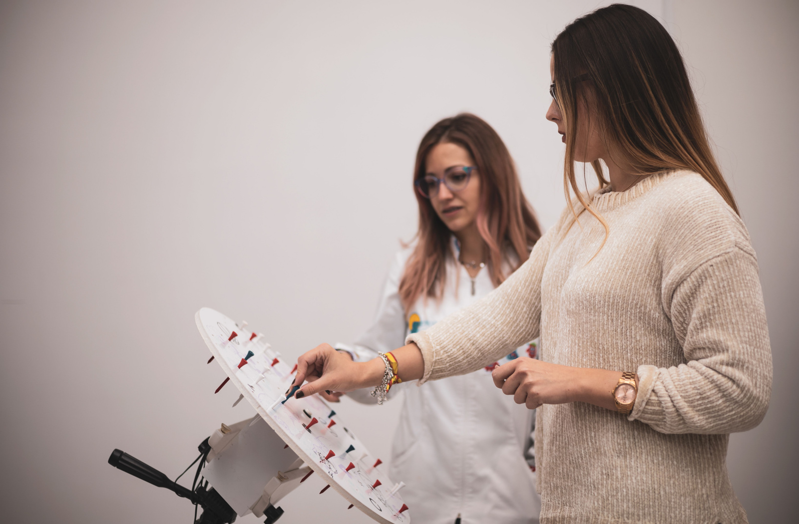 A woman in a sweater undergoing vision therapy conducted by an eye doctor.