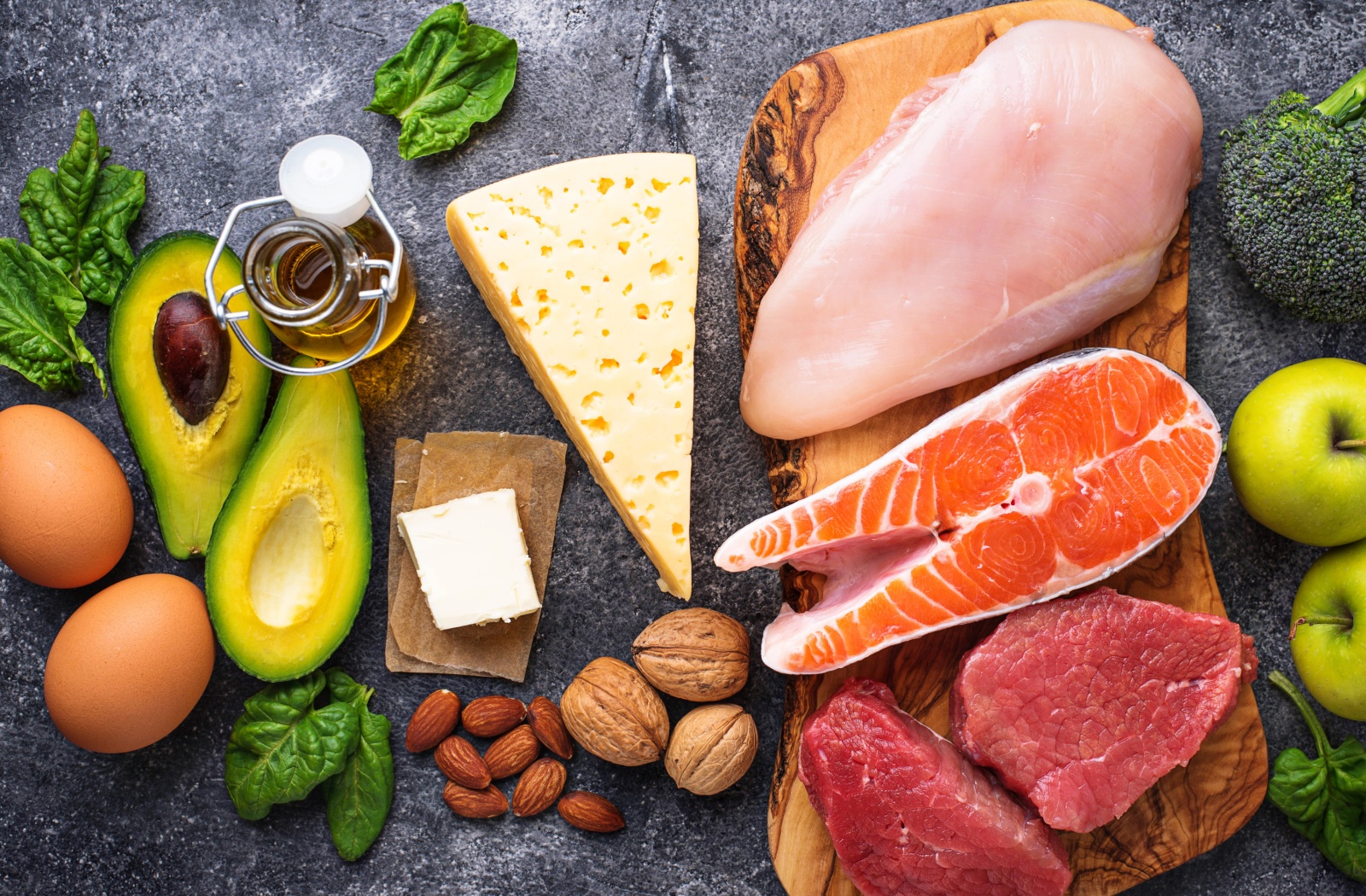 A colorful overview of a balanced diet of meats, greens, nuts, and cheese, high in vitamin content which helps promote ocular health.